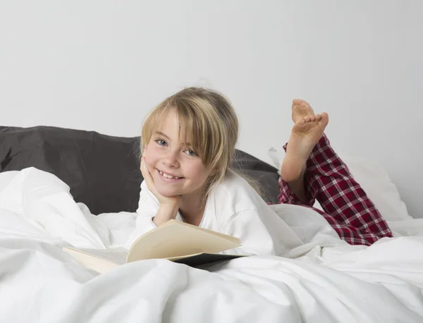 Glimlachend Young Girl lezen een boek — Stockfoto