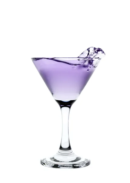 Éclaboussures liquides violettes dans un verre de martini isolé sur bac blanc Images De Stock Libres De Droits