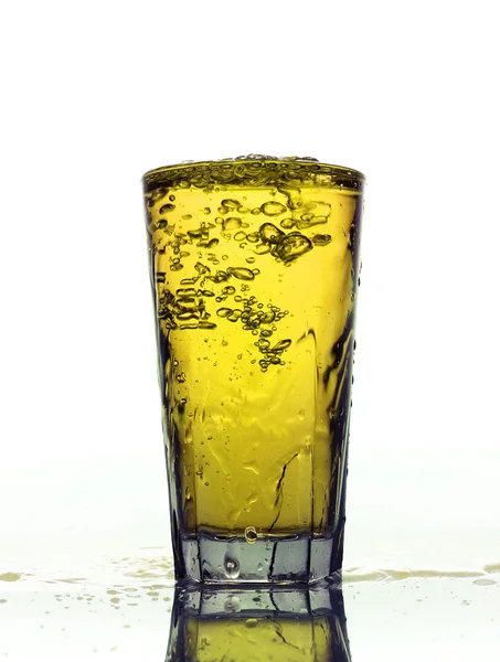 Glas spritzende gelbe Limonade isoliert auf weißem Hintergrund — Stockfoto
