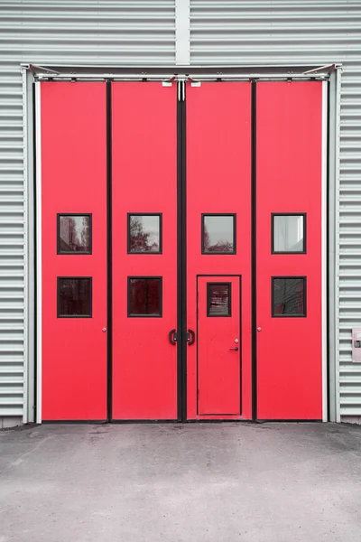 Porta vermelha da garagem em um edifício do armazém — Fotografia de Stock