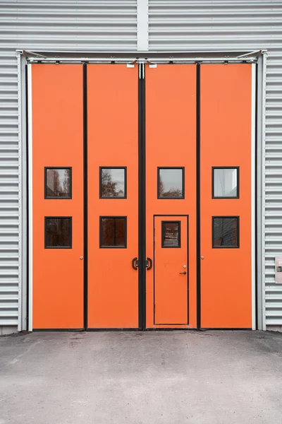 Oranje garagedeur op een magazijn gebouw — Stockfoto