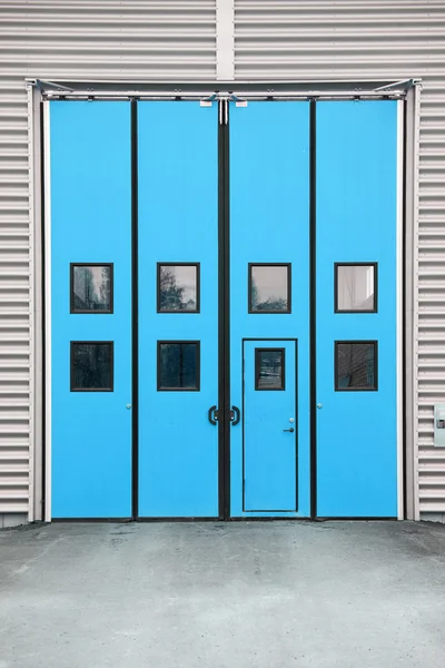 Porta azul da garagem em um edifício do armazém — Fotografia de Stock