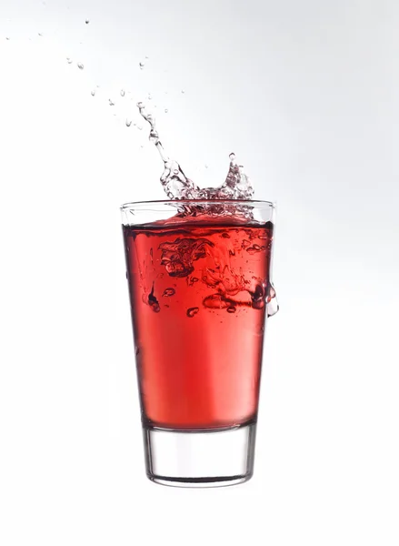 Bir bardak kırmızı limonataya su sıçrat. — Stok fotoğraf