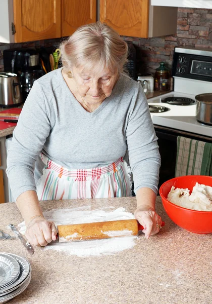 Donna anziana rotolamento pasta — Foto Stock