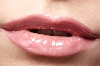 Kadının dudakları ile moda doğal bej ruj makyaj close-up. Yatay makro seksi soluk lipgloss makyaj