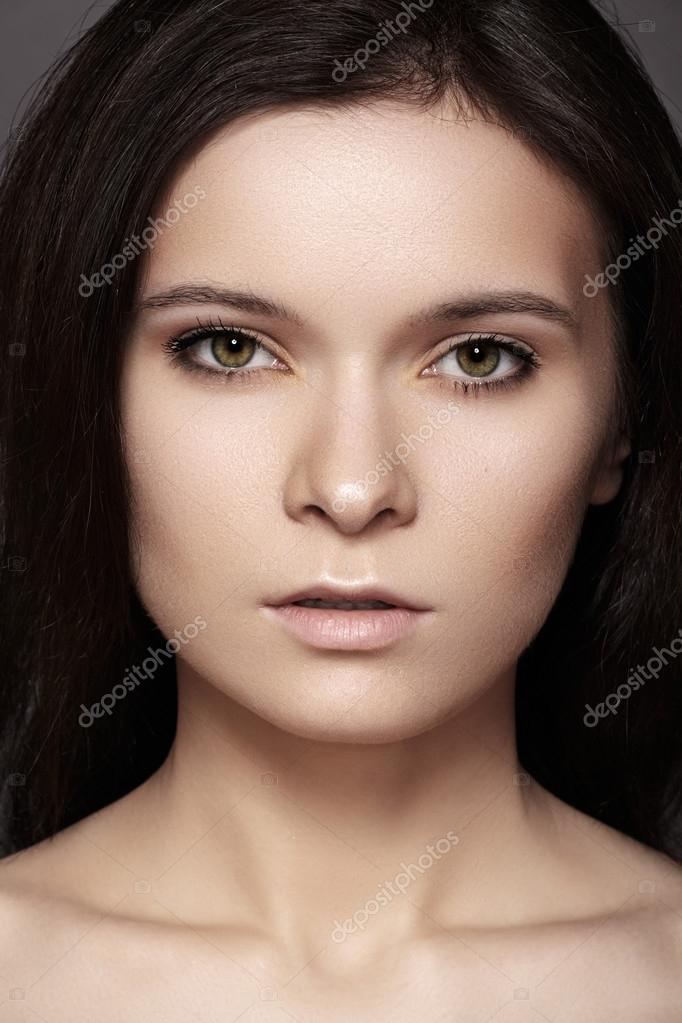 Beautiful woman model with perfect dark hair style, natural eye makeup and pale lips, clean