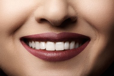 Close-up happy female smile with healthy white teeth, bright magenta lips make-up. Cosmetology, dentistry and beauty care. Macro of woman's smiling mouth clipart
