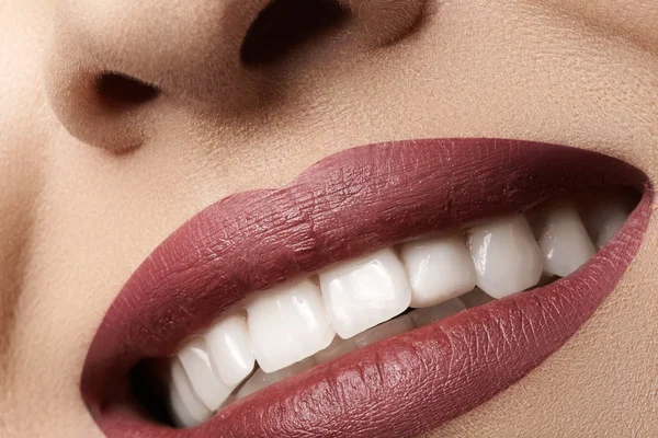 Close-up gelukkig vrouwelijke glimlach met gezonde witte tanden, lichte magenta lippen make-up. cosmetologie, tandheelkunde en schoonheid zorg. macro van vrouw de lachende mond — Stockfoto