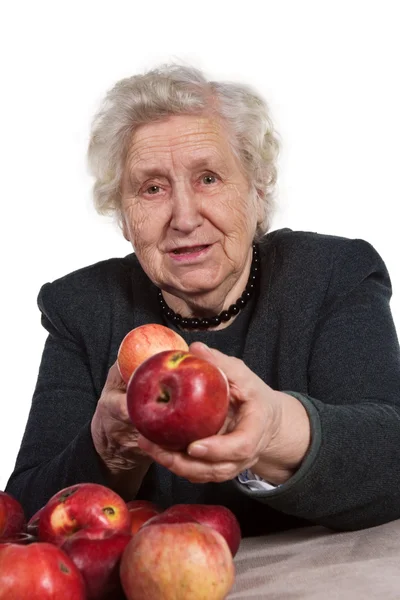 Old woman offering apples — Stock fotografie