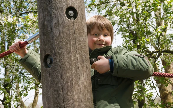Pojken klättrar på lekplats — Stockfoto