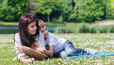 Anne ve oğlu çimenlerde yatıyor.