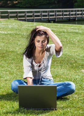 woman with laptop on grass