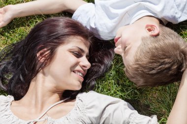 Anne ve oğlu çimenlerde yatıyor.