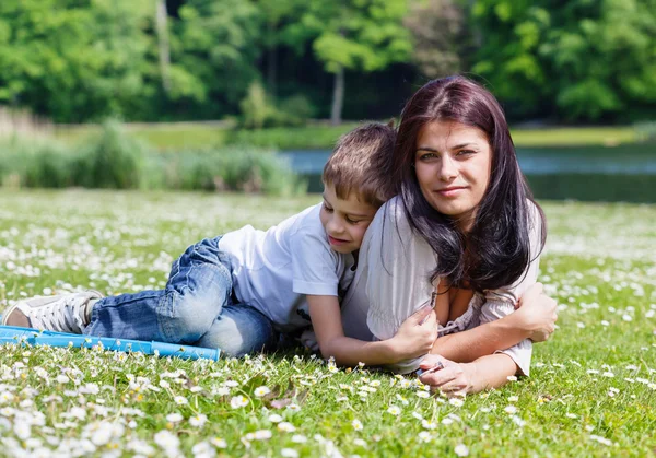 Madre e hijo tendidos en la hierba —  Fotos de Stock