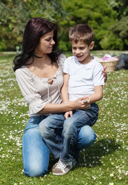 Woman on grass with son — Stockfoto