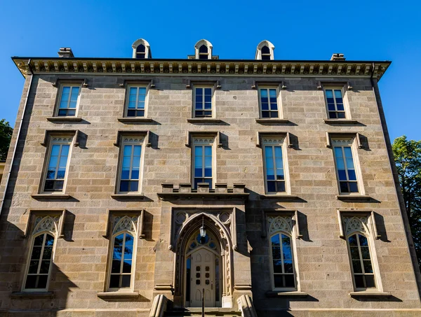 Antiguo edificio de piedra marrón con ventanas azules — Foto de Stock