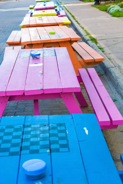 Blauw, roze en oranje picknicktafels — Stockfoto