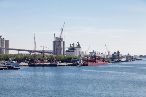 Barcos à vela e navios industriais no porto — Fotografia de Stock