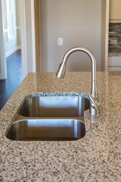 New Brushed Nickel Fixture on Granite Countertop — Stock Photo, Image