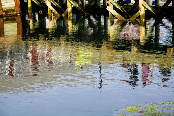 Reflexões coloridas sob o cais — Fotografia de Stock