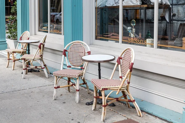 Стулья и круглые столы на тротуаре — стоковое фото