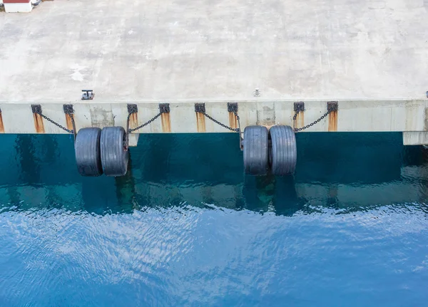 Parachoques de neumáticos encadenados al muelle de hormigón —  Fotos de Stock