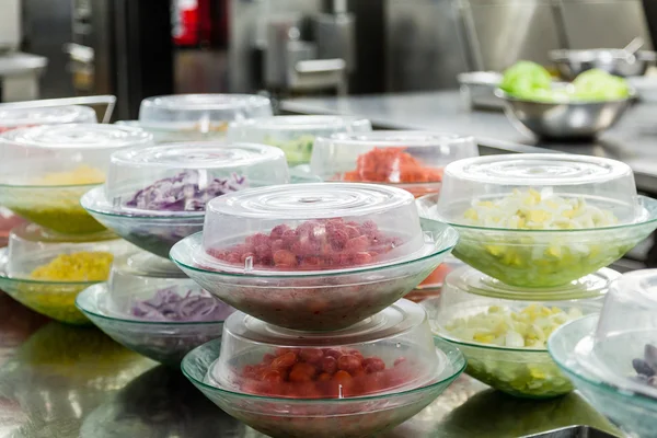 Skär grönsakerna i plast rätter — Stockfoto
