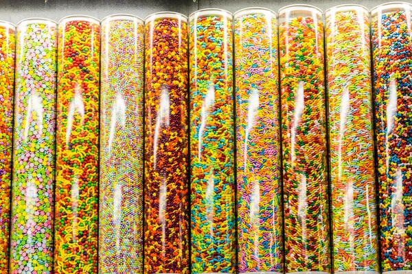 Kleurrijke snoepjes in glazen buizen — Stockfoto