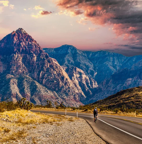 Rider Kerékpározás a sivatagon keresztül a hegyek felé — Stock Fotó