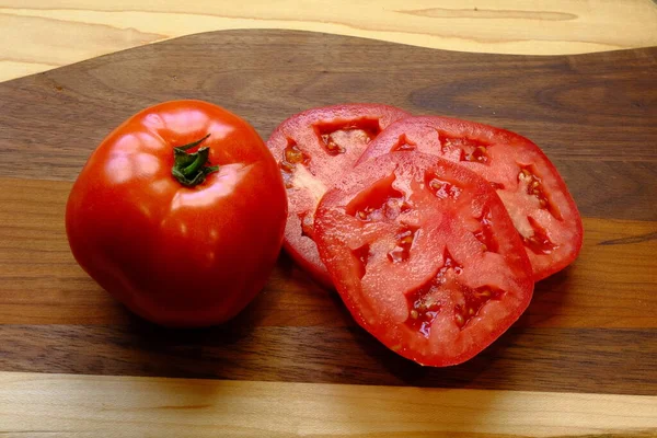 Целые и нарезанные помидоры — стоковое фото