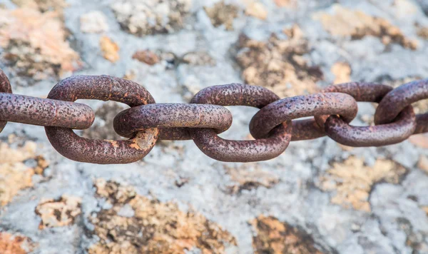 Schwere rostige Kette über Steinmauer — Stockfoto