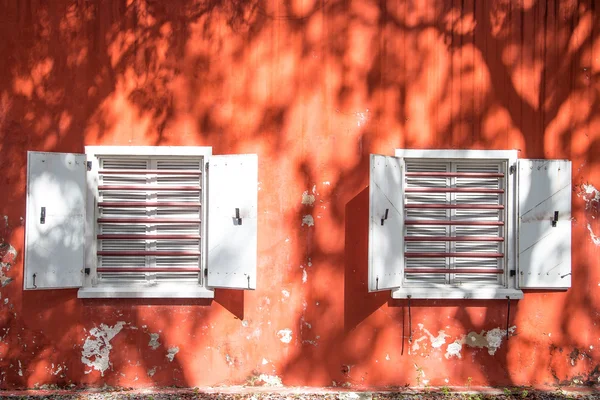 Deux fenêtres blanches sur le vieux mur rouge — Photo