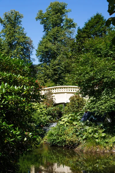 Ponte di intonaco giallo nel giardino formale verde — Foto Stock