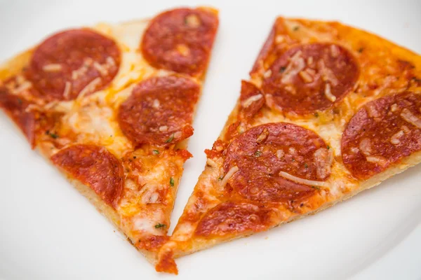 Duas fatias de pizza de pepperoni na placa branca — Fotografia de Stock