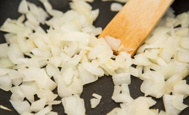 Tahta Spatula ile tavada karıştırarak soğan kıyılmış