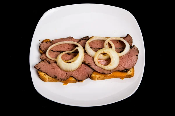 Hot Sliced Beef Sandwich with Onion Rings on Black — Stock Photo, Image