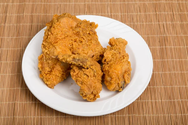 Pollo frito en plato pequeño y mantel de bambú —  Fotos de Stock