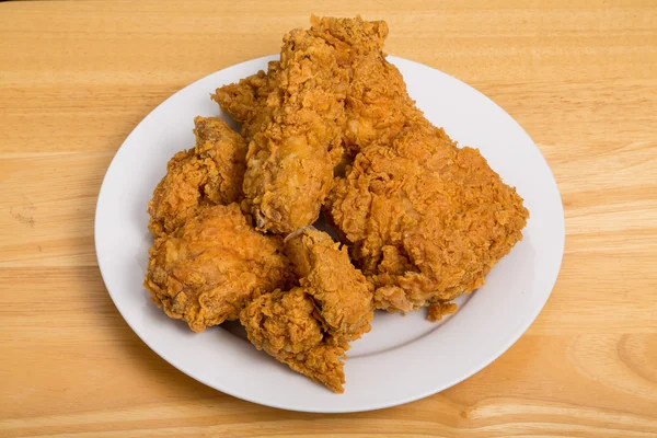 Frango frito crocante na placa branca e mesa de madeira — Fotografia de Stock