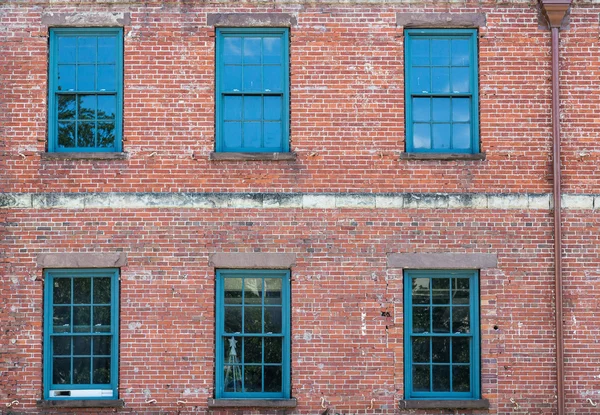 Six fenêtres vertes sur le vieux bâtiment en brique — Photo