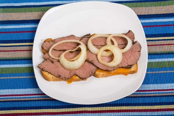 Plátky hovězího masa a cibule sendvič na pruhovaný ručník — Stock fotografie