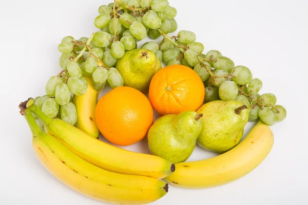 Apelsiner druvor bananer och päron på vit — Stockfoto