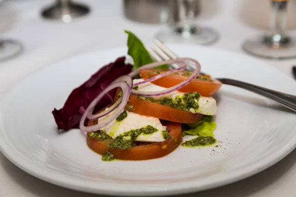 Caprese-Salat mit Tomatenscheiben auf weißem Teller — Stockfoto