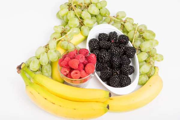 Frambuesas moras uvas y plátanos en blanco —  Fotos de Stock