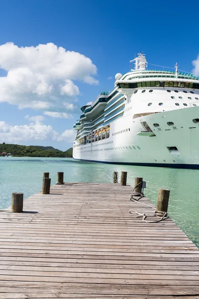 Alter Holzsteg mit Kreuzfahrtschiff im Hintergrund lizenzfreie Stockbilder