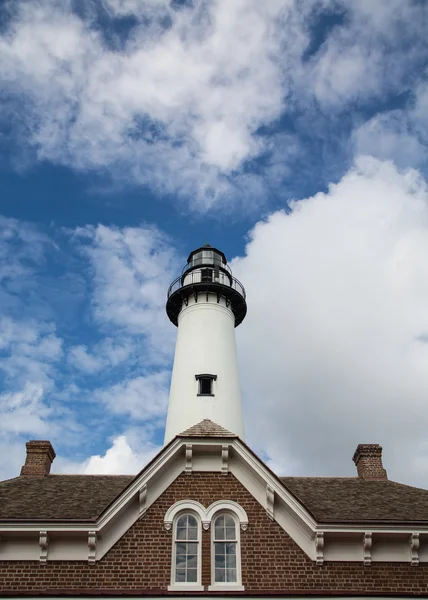 Faro de ladrillo blanco detrás de la casa de ladrillo bajo el cielo agradable — Foto de Stock