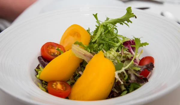 Salada verde de campo com tomates vermelhos e amarelos — Fotografia de Stock