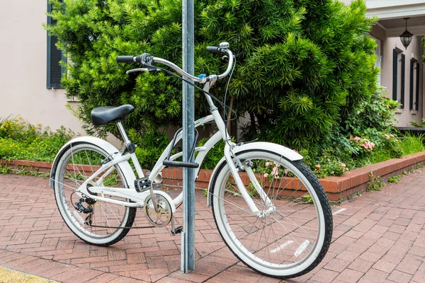 Weißes Fahrrad an einem Wegweiser verschlossen — Stockfoto