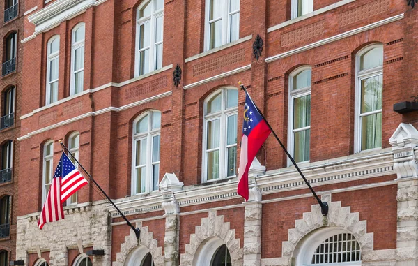 Amerikai és Grúzia zászlók a régi tégla épület — Stock Fotó