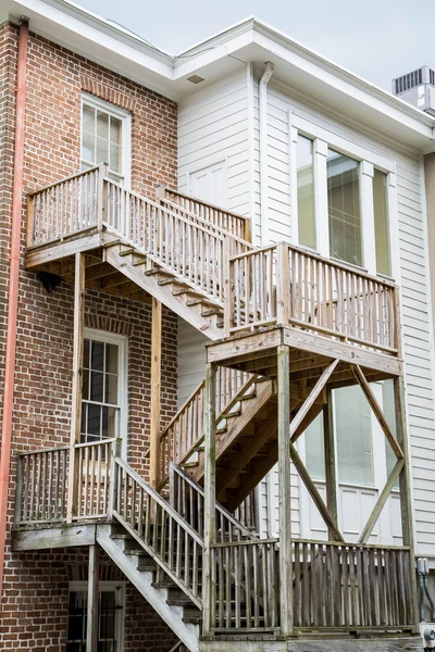 Новые деревянные ступеньки выходят за пределы старых деревянных и кирпичных домов — стоковое фото