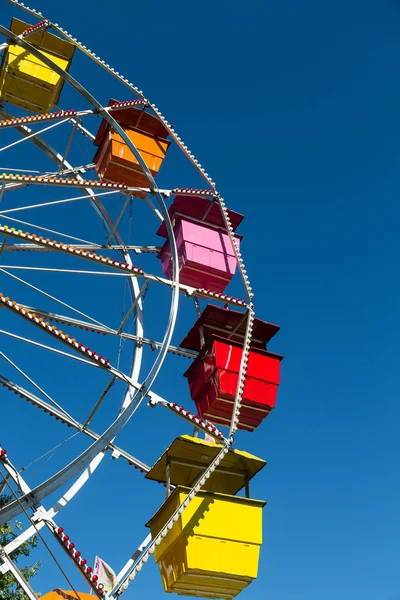 Assentos Multi coloridos na roda gigante no céu azul — Fotografia de Stock